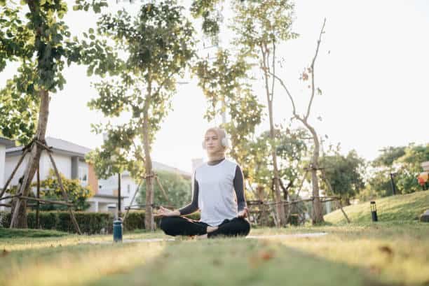 young islam female practicing yoga in the public park